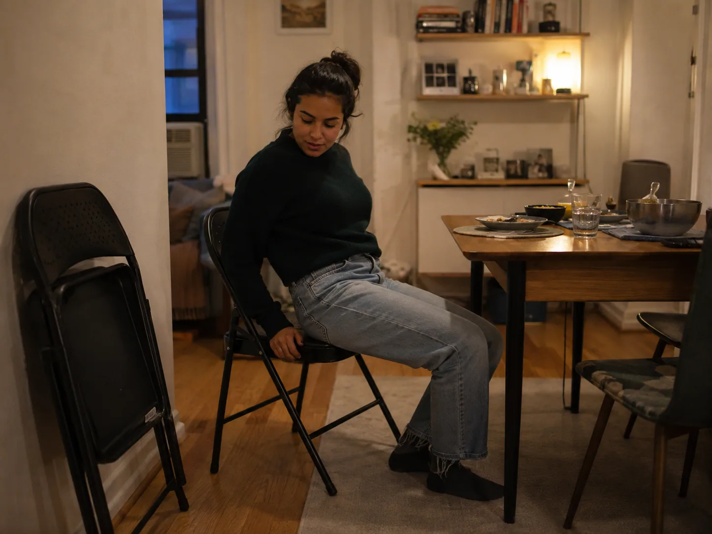 Apartment resident arranging a small folding dining table in a multifunction room
